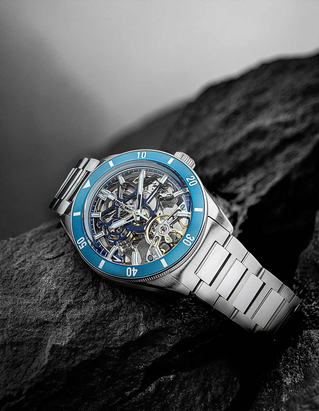 Qorum Equinox Men’s Automatic Skeleton Watch – Steel Finish Dial, Blue Bezel, Stainless Steel Strap