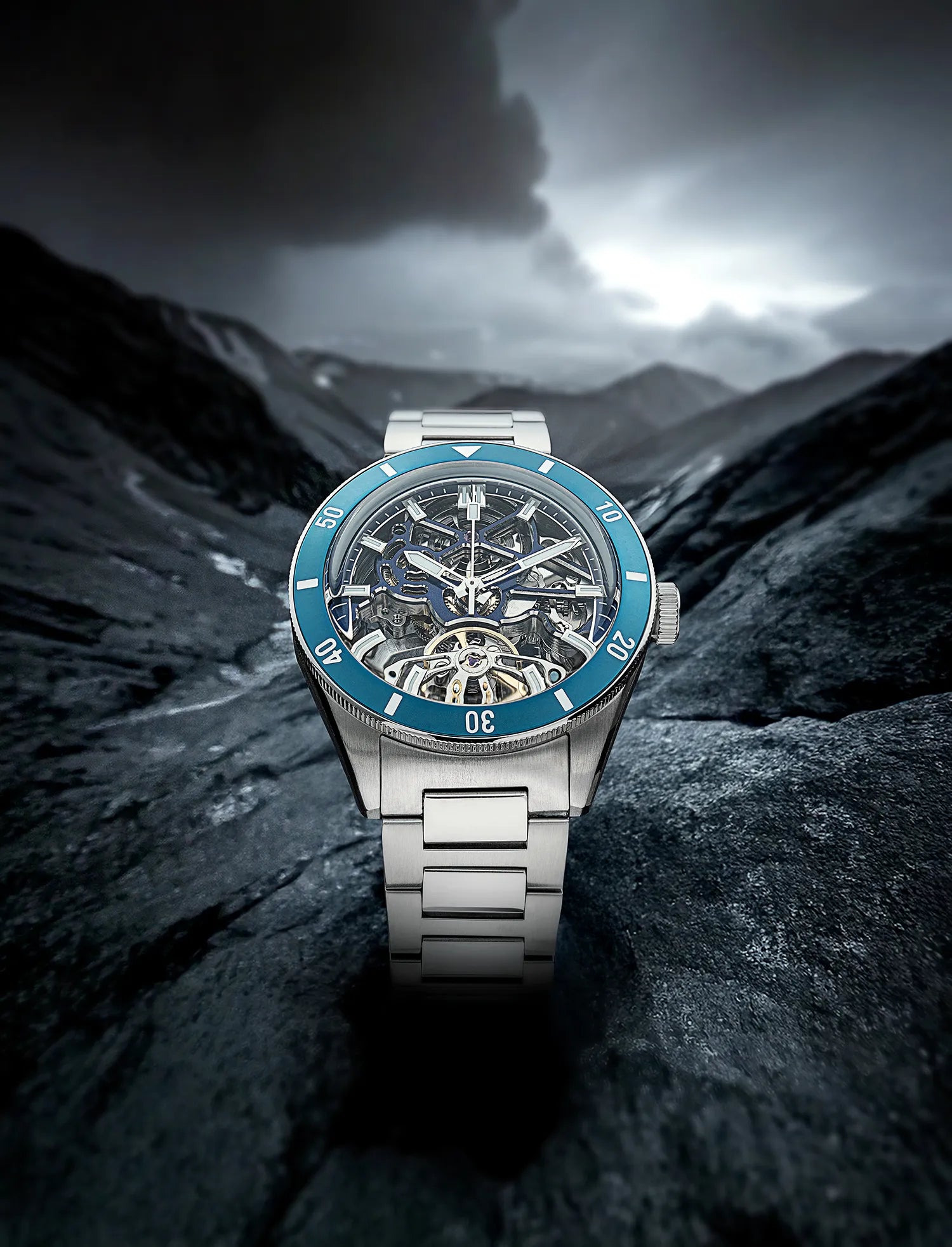 Qorum Equinox Men’s Automatic Skeleton Watch – Steel Finish Dial, Blue Bezel, Stainless Steel Strap